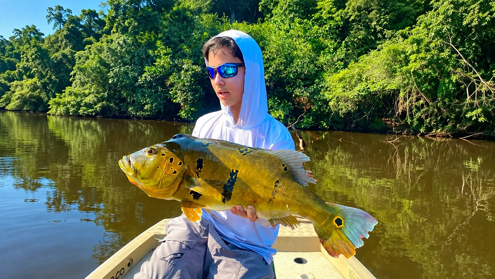 Pescador exibindo um peixe durante uma pescaria